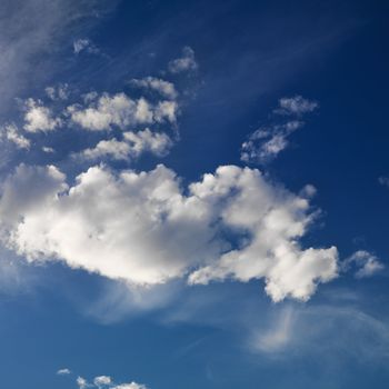 Wispy cloud formations against clear blue sky.