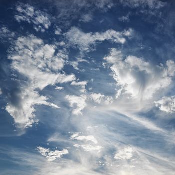 Wispy cloud formations against clear blue sky.