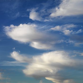 Wispy cloud formations against clear blue sky.