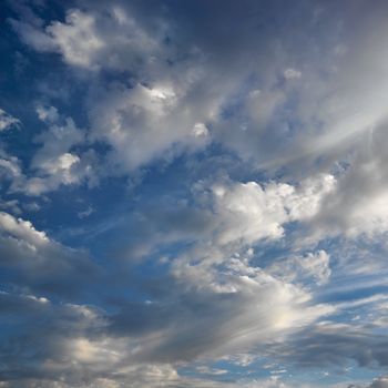 Wispy cloud formations against clear blue sky.