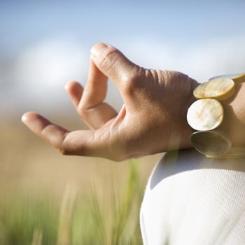 Close-up of young adult Asian female's hands in meditating position.