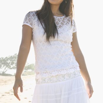 Young adult Asian female at beach with soft lighting.