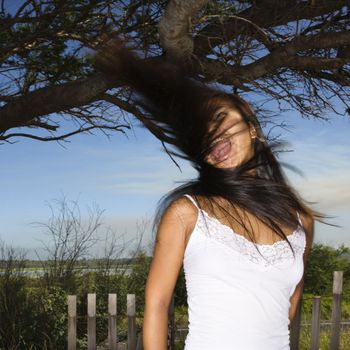 Young adult Asian female screaming and swinging her hair.