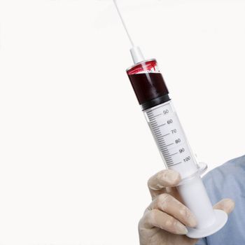 Mid-adult Caucasian male wearing latex medical gloves and holding a syringe.