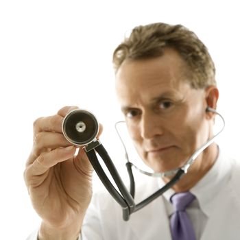 Portrait of a mid-adult Caucasian male doctor holding out stethoscope.