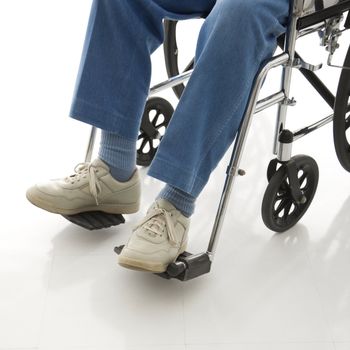 Legs and feet of elderly man sitting in wheelchair.