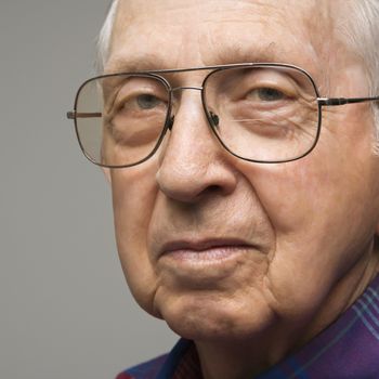 Close-up portrait of elderly man in glasses.