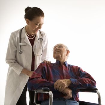 Mid-adult Caucasian female doctor looking at an elderly Caucasian male in wheelchair.