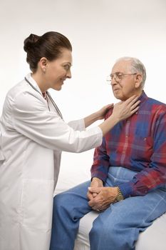 Mid-adult Caucasian female doctor checking an elderly Caucasian male's pulse.