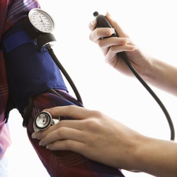 Close-up of mid-adult Caucasian female taking blood pressure of a male.