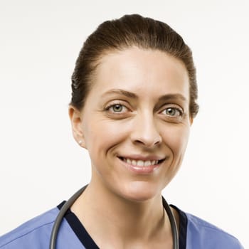 Head shot portrait of Caucasian woman doctor smiling against white background.