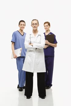 Full-length portrait of Caucasian women healthcare workers in uniforms standing against white background.