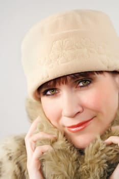 woman wearing a beige hat and factitious fur coat