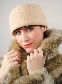 woman wearing a beige hat and factitious fur coat