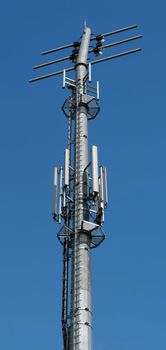 Mast with different antennas, transmitters used for gsm communication on blue sky background