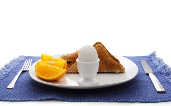 boiled egg, orange and bread as breakfast