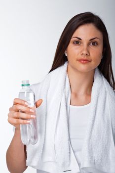 Portrait of a young woman with towel and bottle of water over white