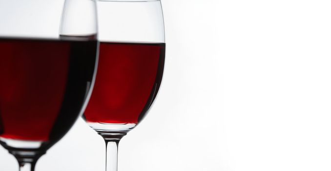 Red wine on white background. Focus is on the second glass