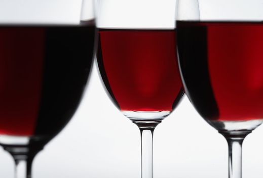 Three glasses of red wine. Focus is on the middle glass.