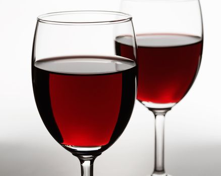 Red wine on white background. Focus is on the first glass