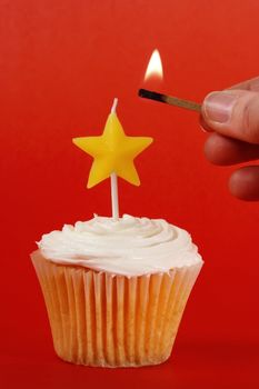 homemade cupcakes with icing and star candle