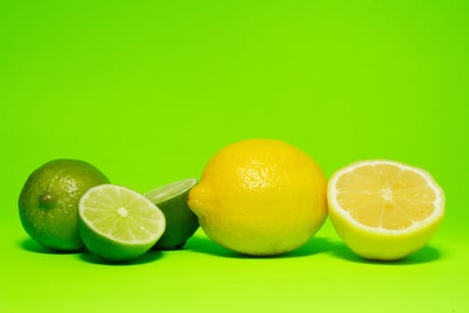 fresh lemon and lime on green background