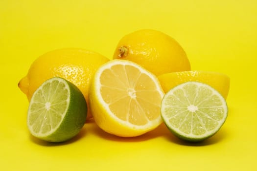 fresh lemon and lime on yellow background