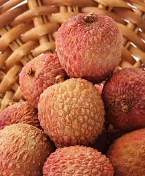 some fresh whole ripe lichees on a wicker basket