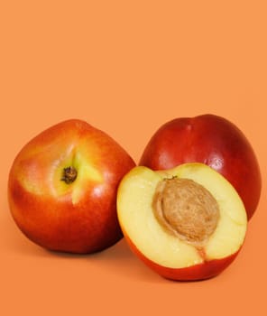 three nectarines with peach background