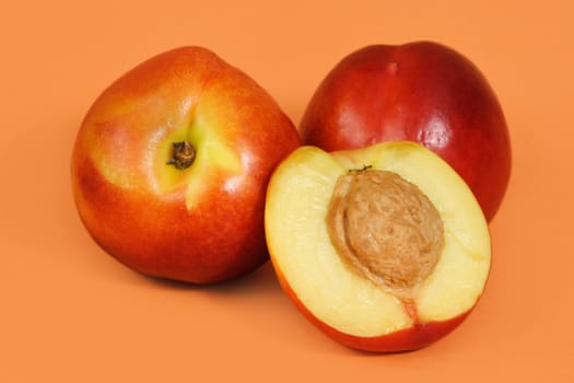 three nectarines with peach background