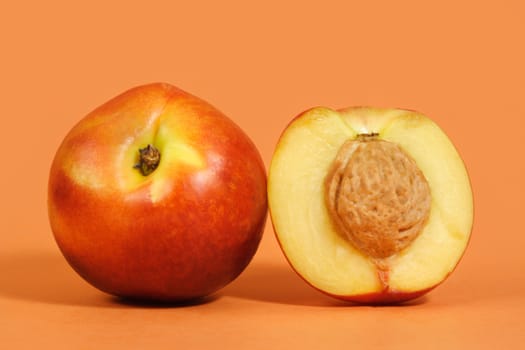 two nectarines with peach background