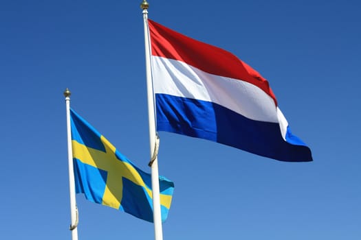 Two flags in the wind, Swedish and Dutch flag