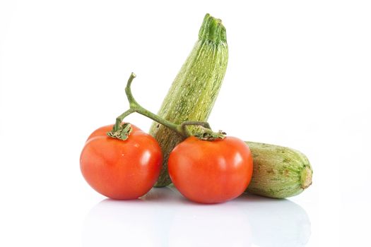 two courgettes and two tomatoes isolated on white background