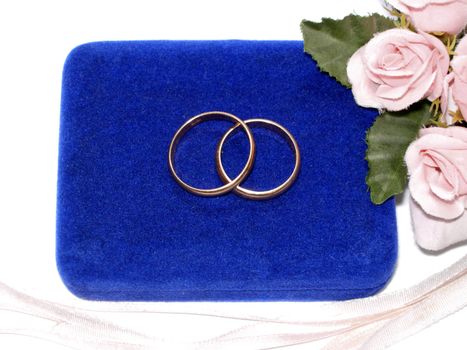 Wedding rings on a blue background with flowers