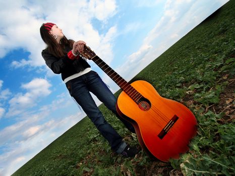 rock girl with guitar on the field