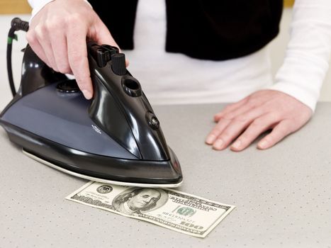 Ironing a hundred dollar bank note