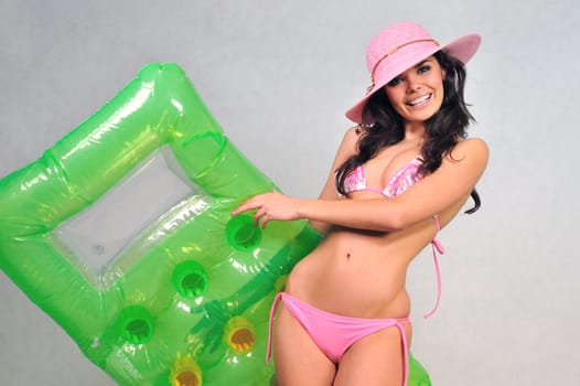 girl in a pink bikini summer hat and inflatable mattress