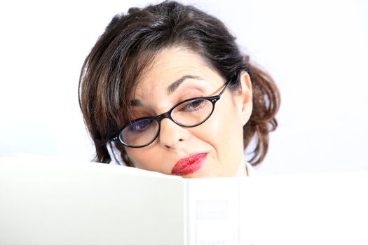 A young woman hides behind a folder or book - closeup