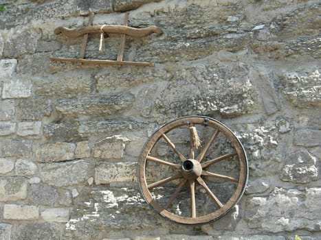 The ancient wheel on a background of a wall