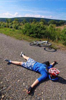The tired bicyclist on an asphalt path under the scorching sun
