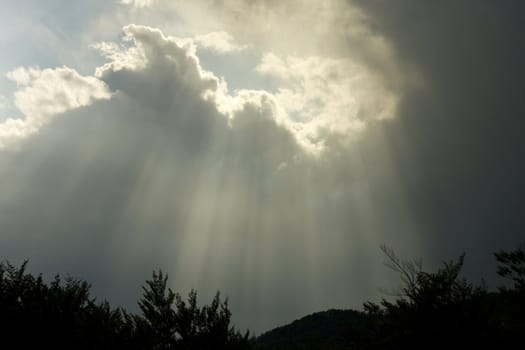 Beam of sun light and grey rain clouds