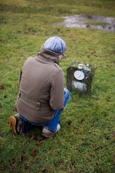 A woman looking at a grave and remembering