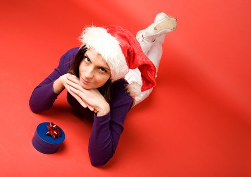 A young woman with a present isolated on red