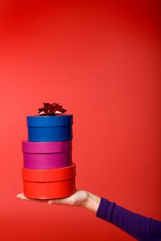 A stack of three gifts isolated on red with room for copy space