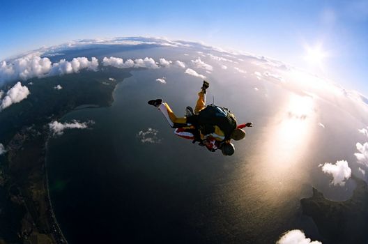 Portrait of two tandem skydivers in action parachuting through the air.