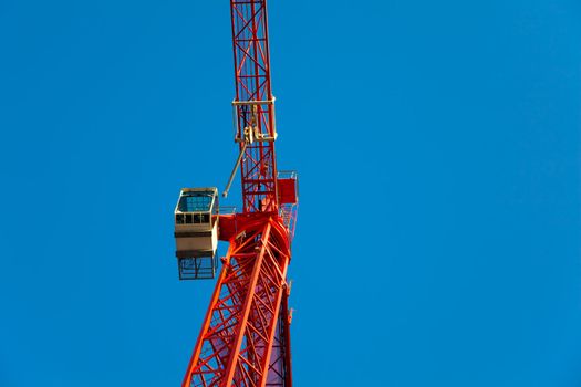 Red crane against blue sky.