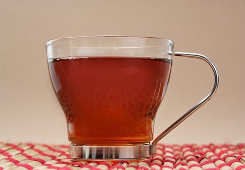 cup of tea over a red tablecloth, beige background