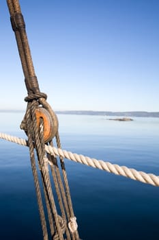 A boat pulley and rope system against a ocean landscape.