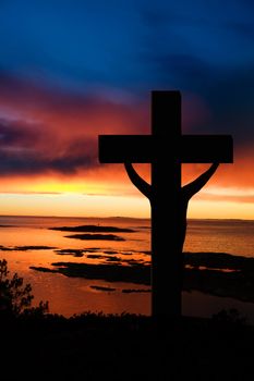 A cross at sundown on the ocean