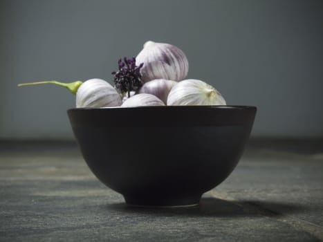 bowl full of fresh garlic on dark background